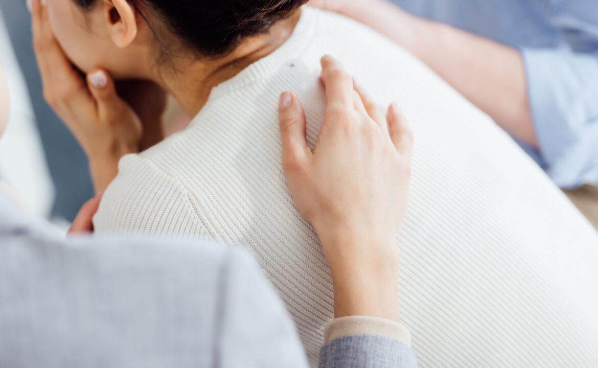 cropped view of woman consoling another woman during therapy meeting